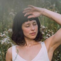 Ein Foto der Musikerin Almuth in einer hohen Wiese.