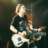 Bild eines Musikers bei einem Konzert mit Gitarre singend