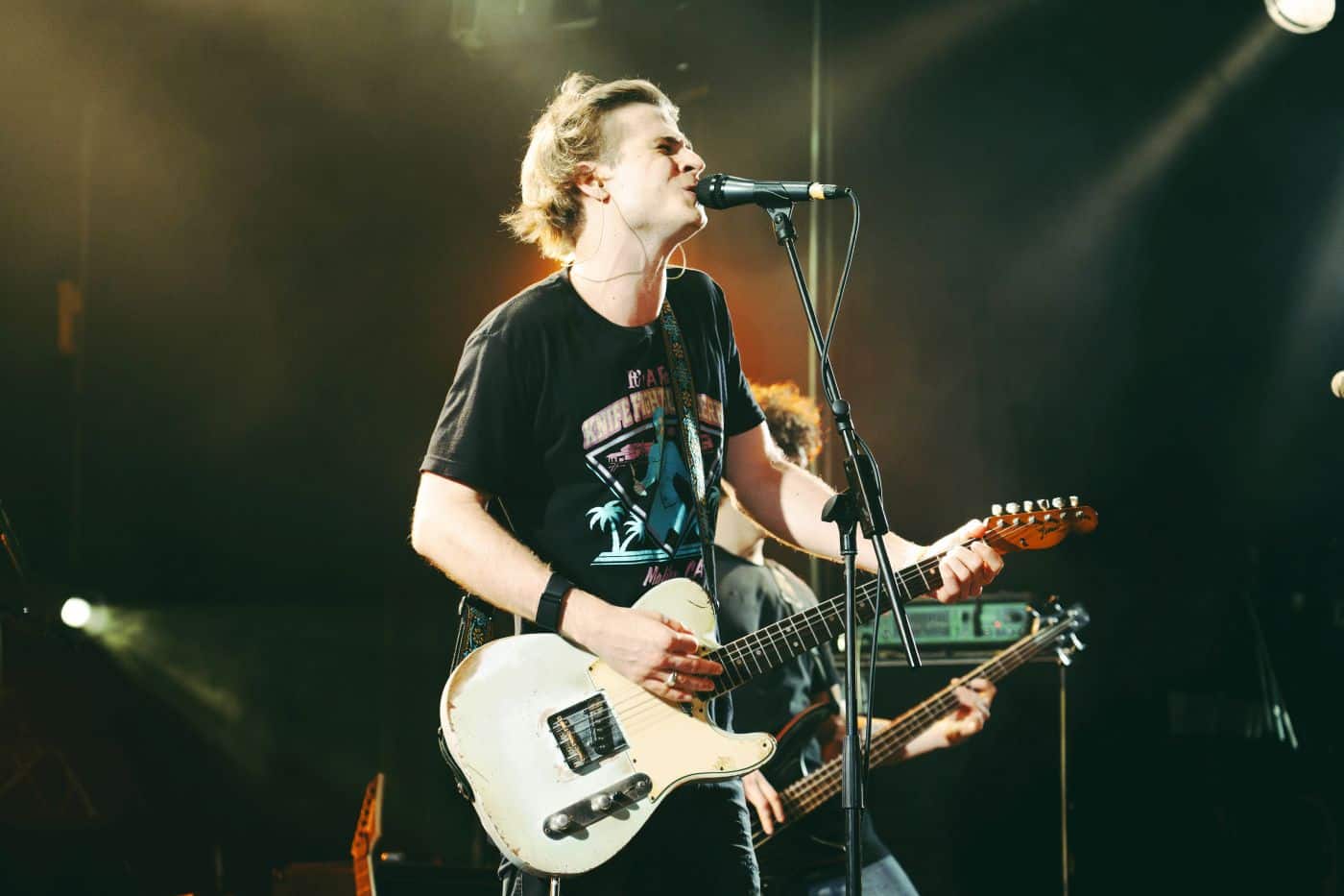 Bild eines Musikers bei einem Konzert mit Gitarre singend