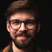 Porträtbild des Musikers und Komponisten Christoph Suttner vor schwarzem Hintergrund