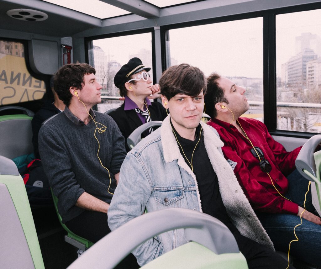 Der Liedermacher Der Nino aus Wien und seine Band in einem Bus