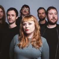 Die sechsköpfige Band Dirty Talons vor einem grauen Hintergrund