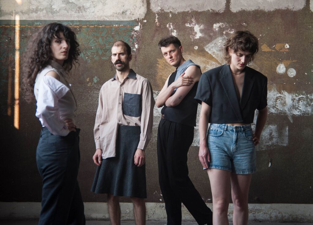 Die vierköpfige Band Endless Wellness vor einer nicht fertig gestrichenen Mauer