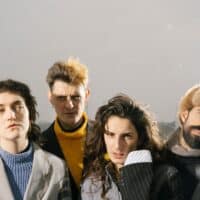 Die vierköpfige Band Endless Wellness auf einer Brücke während es schneit