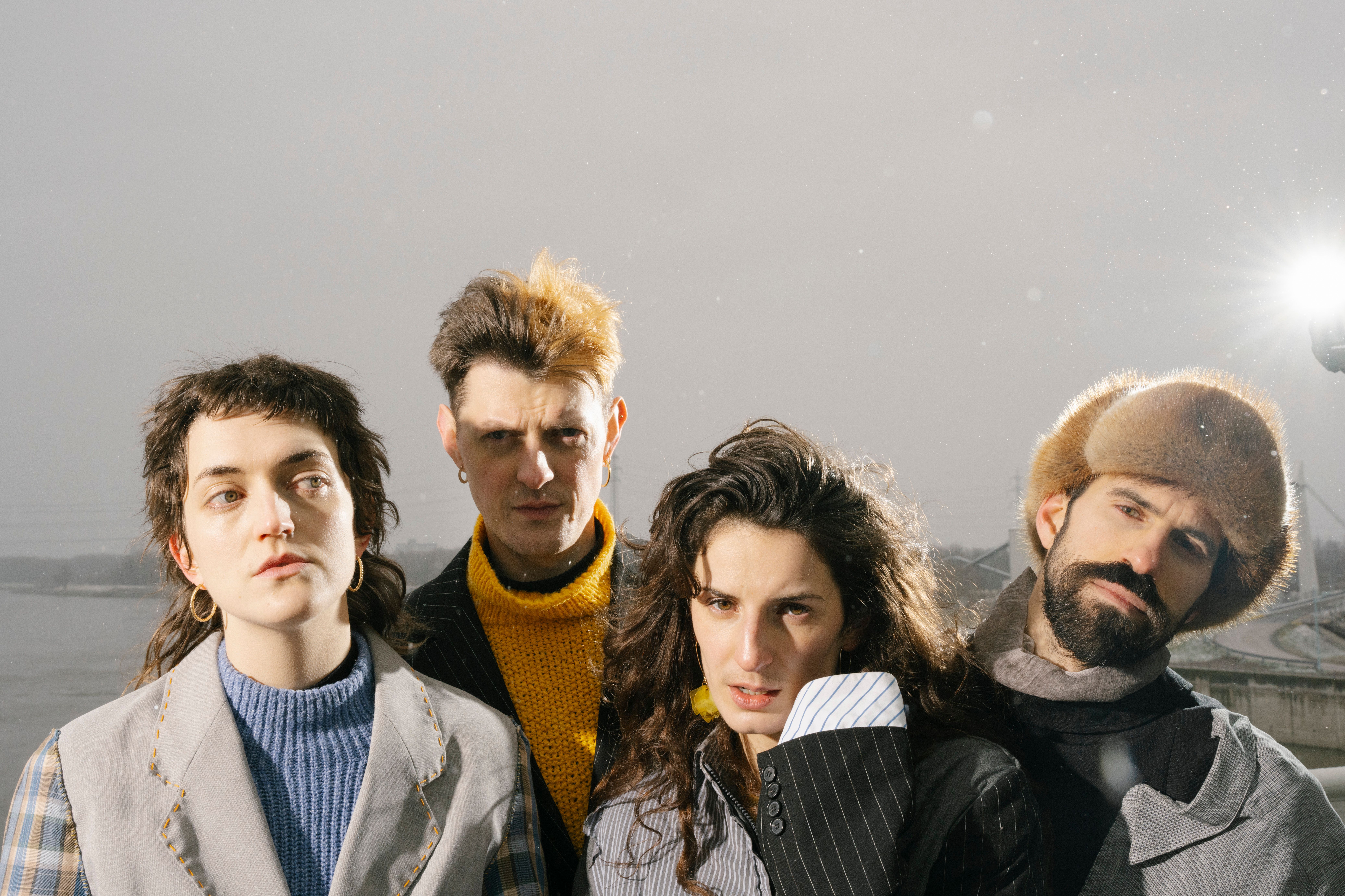 Die vierköpfige Band Endless Wellness auf einer Brücke während es schneit