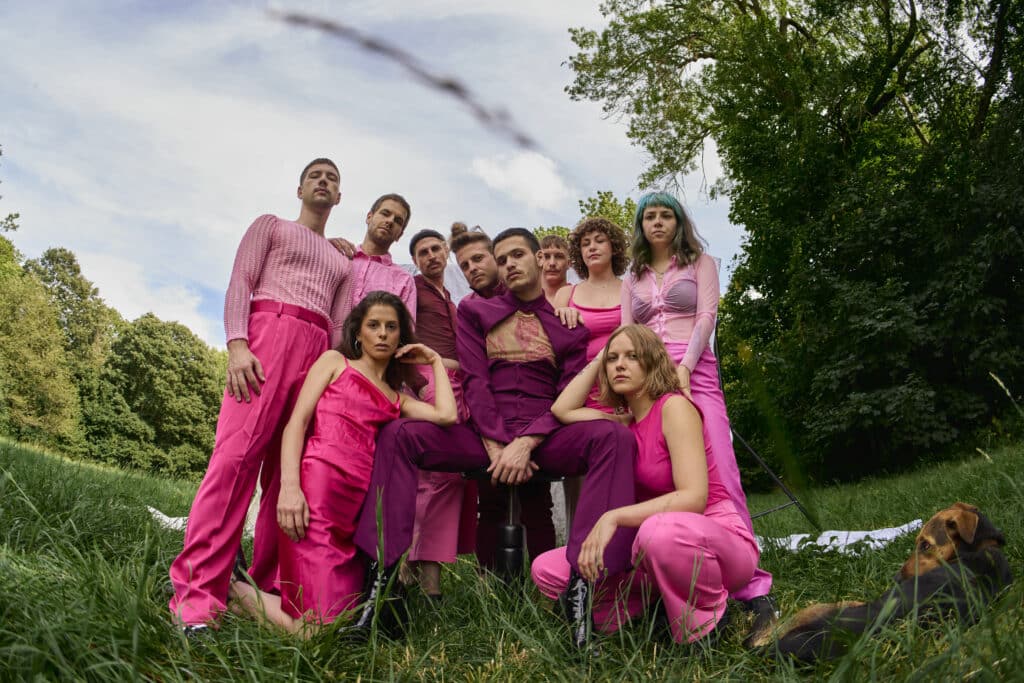 Die Band Keyhan and the Junes und einem Hund auf einer grünen Wiese