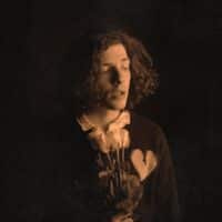 Bild des Musikers Matei Balasoiu aka THE HRTBRK mit Blume in der hand vor schwarzem Hintergrund