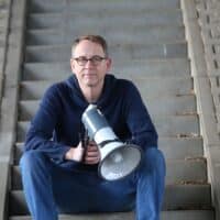 Bild Michael-Behrendt_sitzend-Stufen-Megaphon