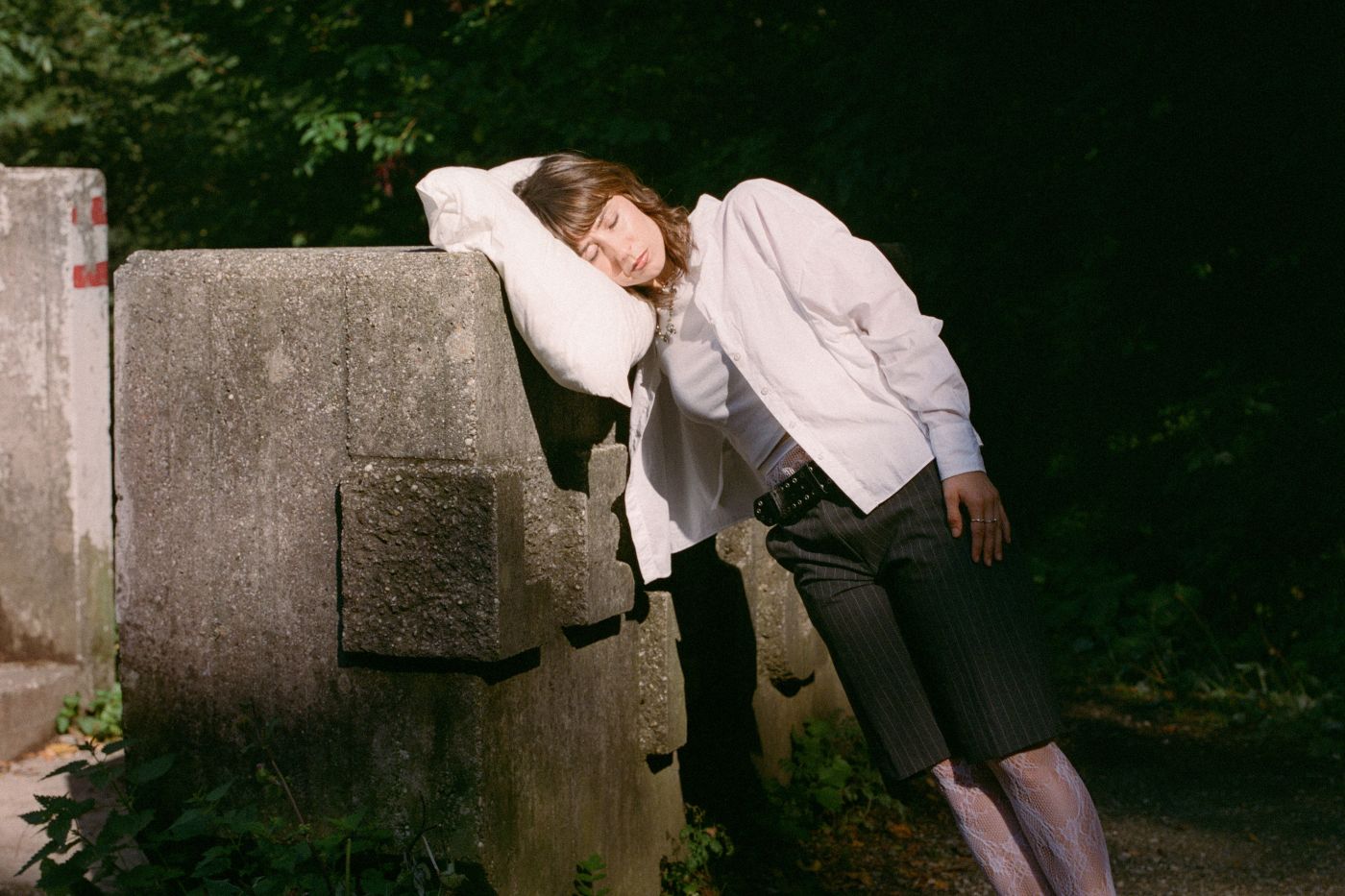 Bild der Musikerin Pippa an einem Betonblock lehnend mit geschlossenen Augen