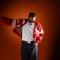 Der Rapper Evan Parks vor einem dunkelorangen Hintergrund