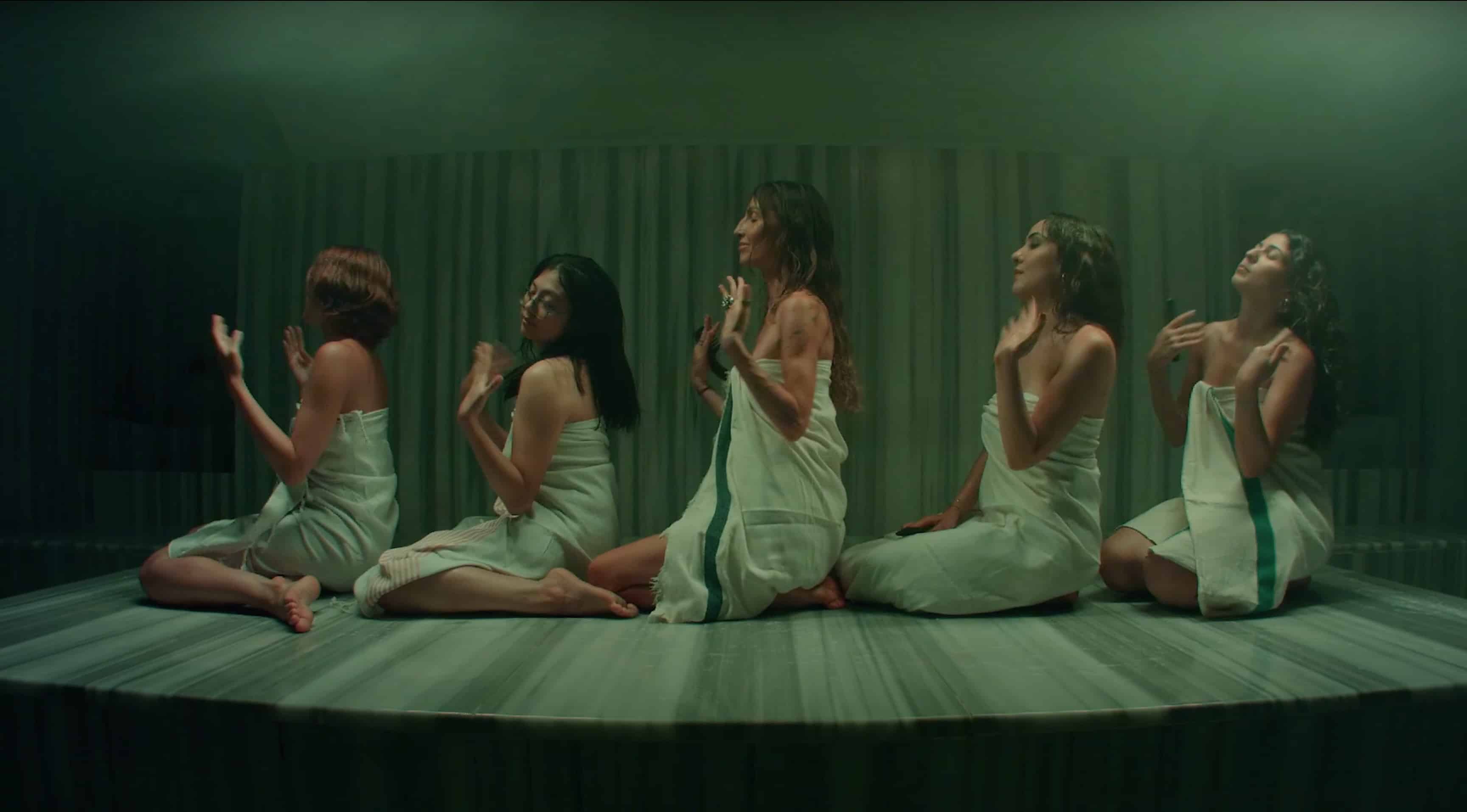 Videostill aus "Tencere". Fünf Frauen sind in einem smaragdgrünen Hamam zu sehen.