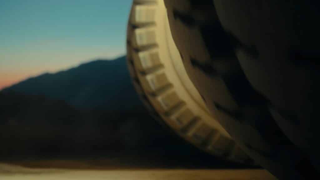 Videostill aus "Girl Loves Me". Eine Detailaufnahme eines Reifens von einem Erzberg-Fahrzeug wird gezeigt.