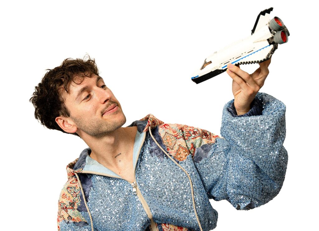 Der Künstler palffi mit einem Lego-Spaceshuttle in der Hand.